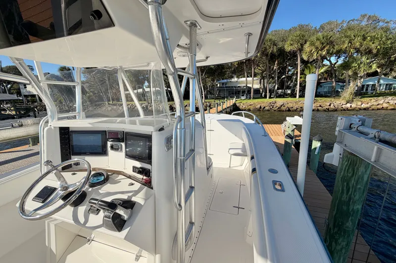 Slide: The Image of 2004 Venture 34 Cuddy boat cockpit with steering wheel and navigation equipment at dock. - 26