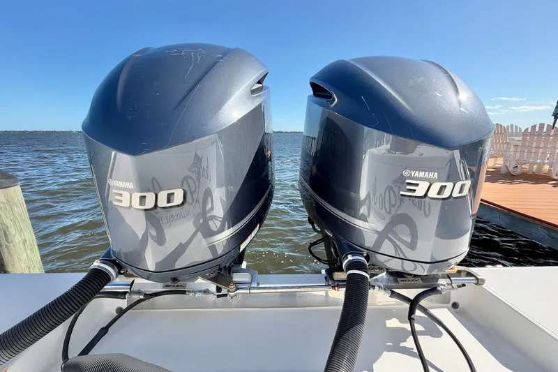 Slide: The Image of Twin Yamaha 300 outboard engines on a 2004 Venture 34 Cuddy boat by the water. - 85