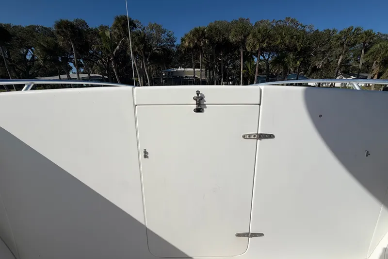 Slide: The Image of 2004 Venture 34 Cuddy boat deck with closed hatch, surrounded by trees. - 69