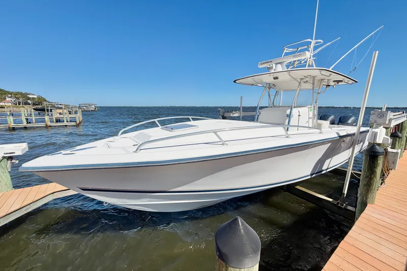 Slide: The Image of 2004 Venture 34 Cuddy boat docked by the water on a sunny day. - 5