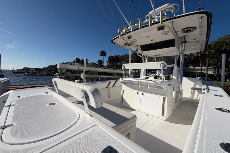Slide: The Image of 2004 Venture 34 Cuddy boat interior with helm, seating, and fishing rod holders. - 14