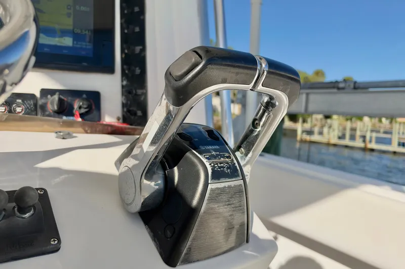 Slide: The Image of Throttle controls on a 2004 Venture 34 Cuddy boat, with a marina in the background. - 23
