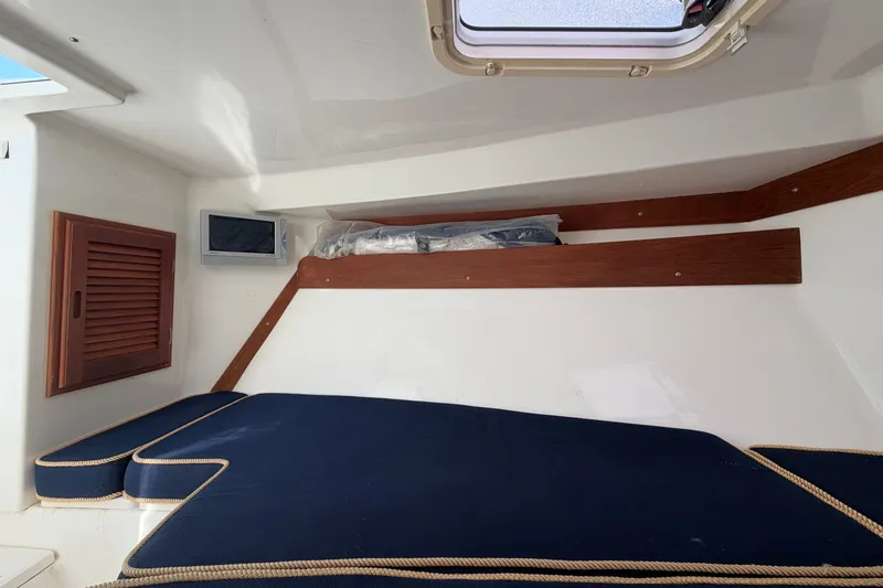 Slide: The Image of 2004 Venture 34 Cuddy cabin interior with blue cushions and wooden accents. - 72