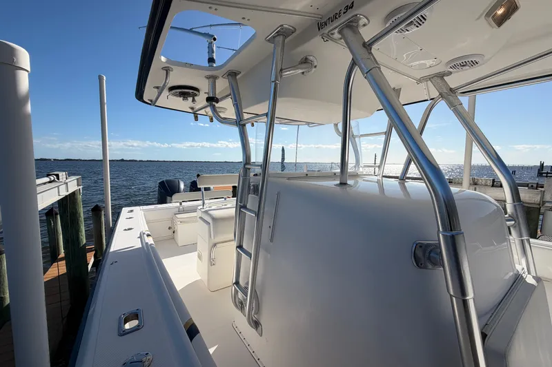 Slide: The Image of 2004 Venture 34 Cuddy boat docked by the water on a sunny day. - 66