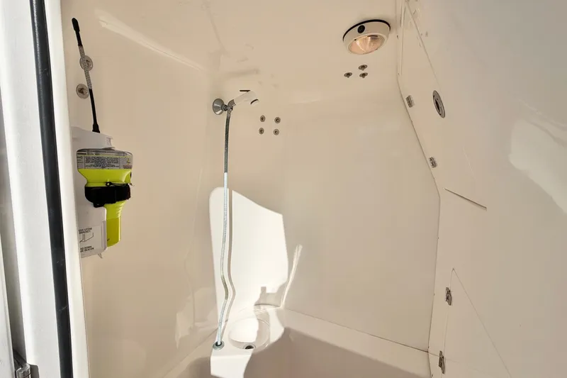 Slide: The Image of Interior of 2004 Venture 34 Cuddy boat, featuring a compact bathroom with showerhead. - 44