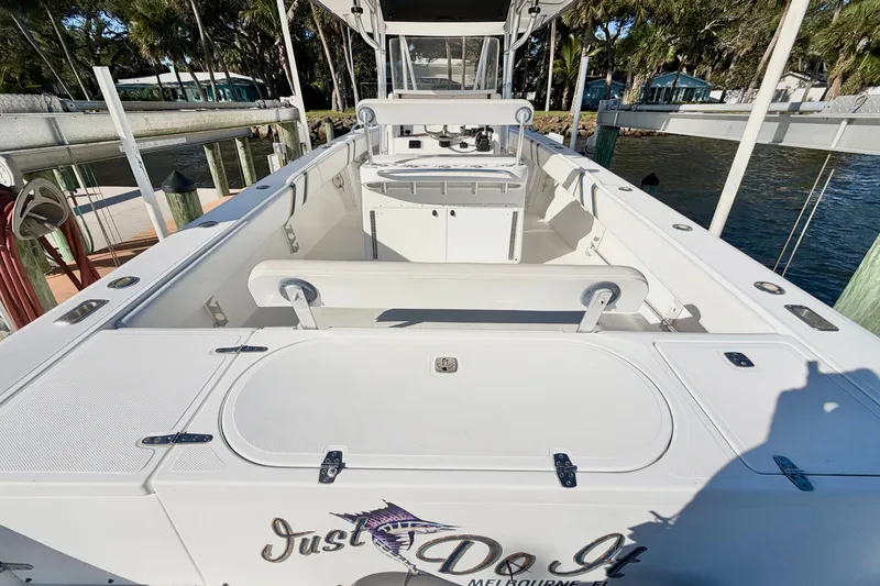 Slide: The Image of 2004 Venture 34 Cuddy boat docked, featuring spacious deck and fishing equipment. - 10