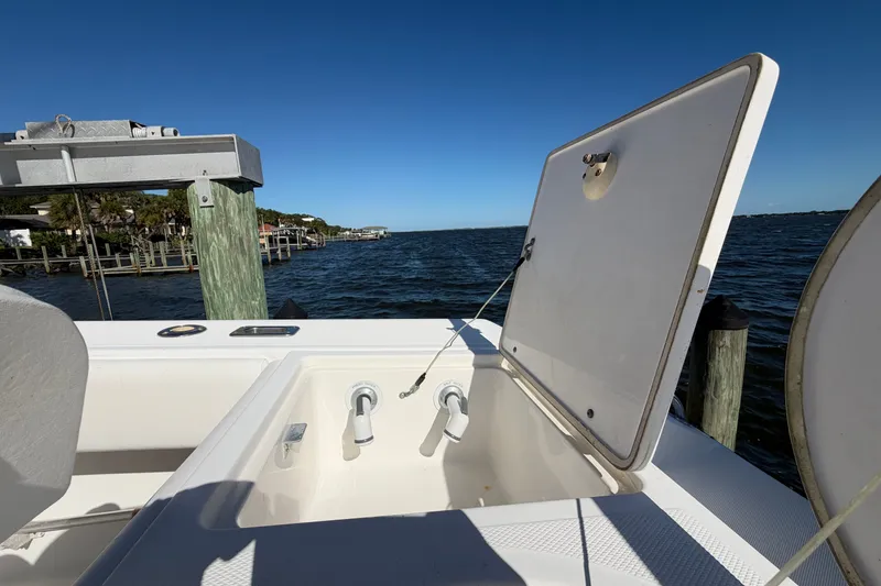 Slide: The Image of 2004 Venture 34 Cuddy boat with open hatch, docked by the water. - 79