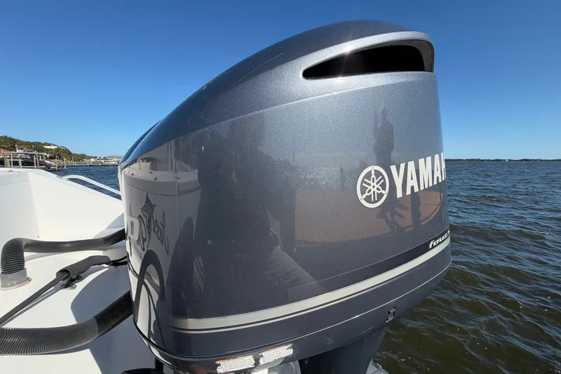 Slide: The Image of Yamaha outboard motor on 2004 Venture 34 Cuddy boat, docked by the water. - 88