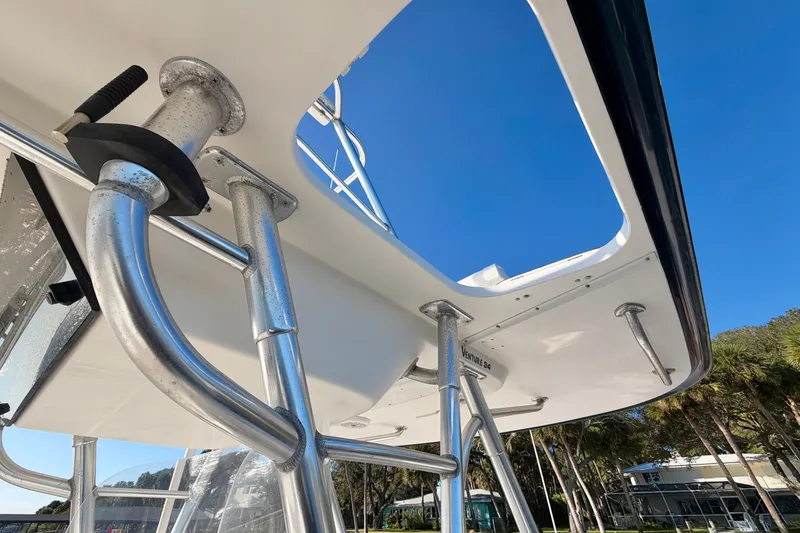 Slide: The Image of 2004 Venture 34 Cuddy boat with stainless steel railings under clear blue sky. - 28