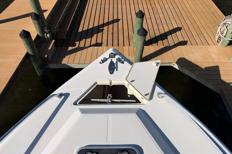 Slide: The Image of Bow of a 2004 Venture 34 Cuddy boat docked at a wooden pier. - 33