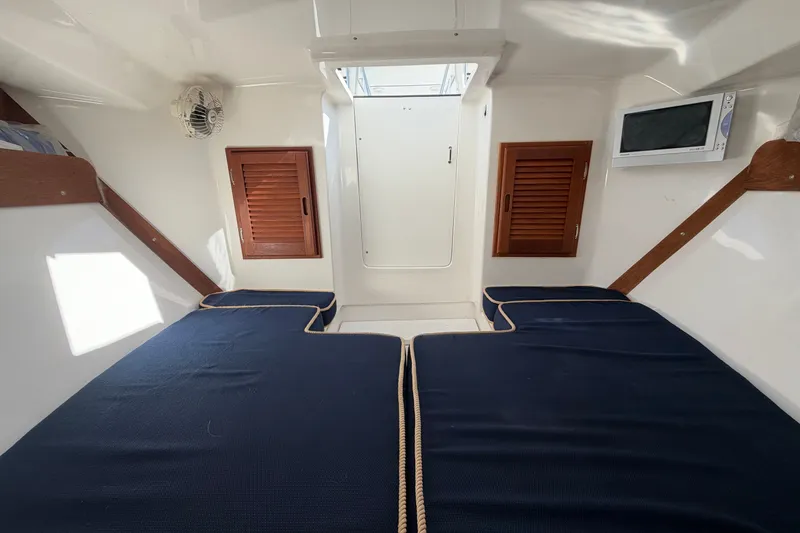 Slide: The Image of 2004 Venture 34 Cuddy cabin interior with blue cushions and wooden accents. - 75