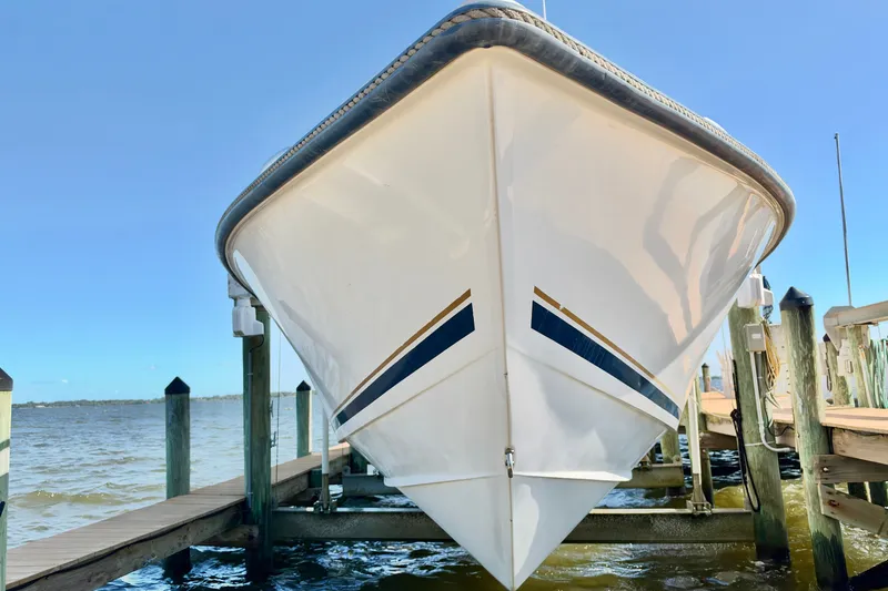 Slide: The Image of Front view of a 2004 Venture 34 Cuddy boat docked by the water. - 3