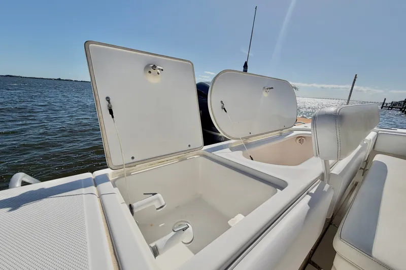 Slide: The Image of 2004 Venture 34 Cuddy boat with open storage compartments, ocean view in background. - 77