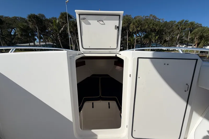Slide: The Image of 2004 Venture 34 Cuddy cabin entrance with open hatch, surrounded by trees. - 70