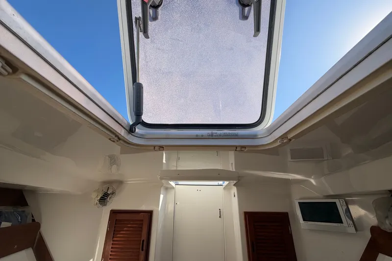Slide: The Image of Interior view of 2004 Venture 34 Cuddy boat with open hatch and wooden accents. - 74