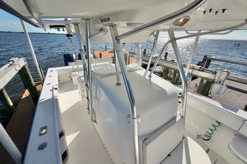 Slide: The Image of 2004 Venture 34 Cuddy boat docked by the water on a sunny day. - 52