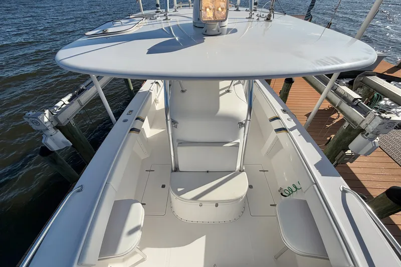 Slide: The Image of 2004 Venture 34 Cuddy boat docked, showcasing spacious deck and seating area. - 49