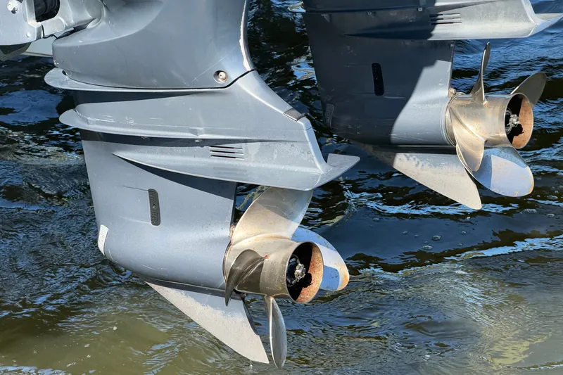 Slide: The Image of Twin outboard motors of a 2004 Venture 34 Cuddy boat in water. - 8