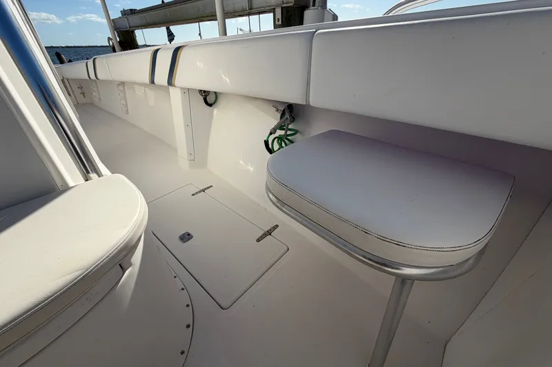 Slide: The Image of 2004 Venture 34 Cuddy boat interior with white seating and storage compartments. - 60