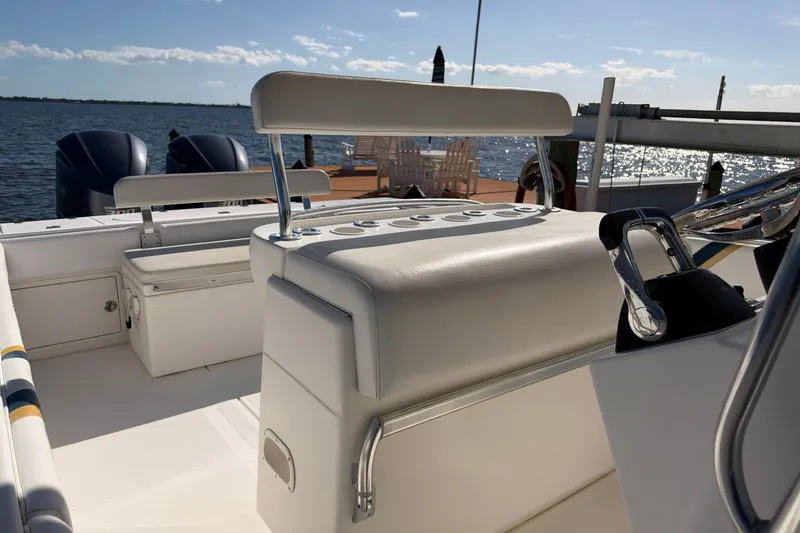 Slide: The Image of 2004 Venture 34 Cuddy boat interior with seating and dual engines, docked by the water. - 67