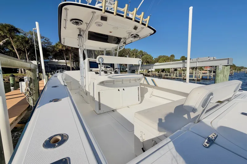 Slide: The Image of 2004 Venture 34 Cuddy boat docked, showcasing spacious deck and seating area. - 13