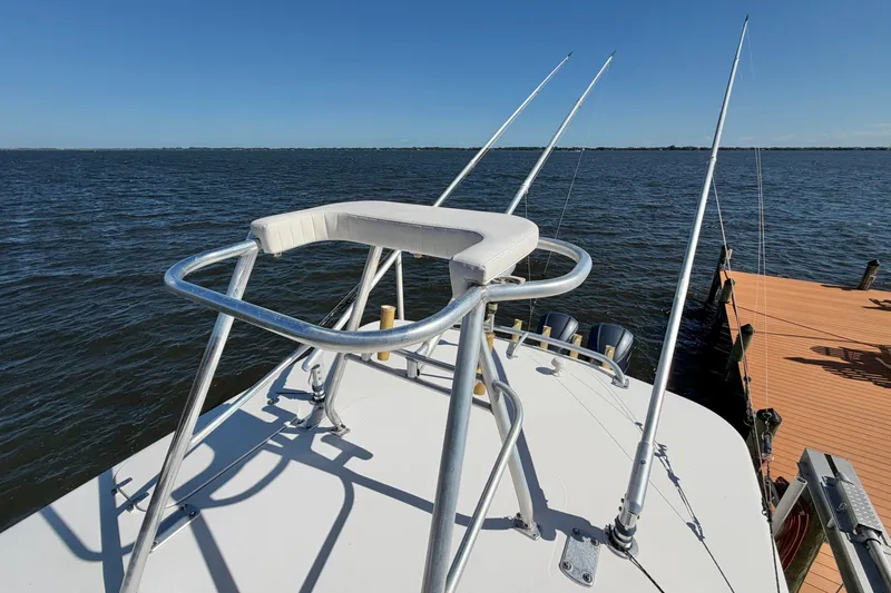 Slide: The Image of 2004 Venture 34 Cuddy boat with fishing rods, docked by the water. - 94