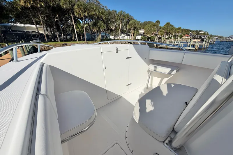 Slide: The Image of 2004 Venture 34 Cuddy boat interior with white seating and storage, dockside view. - 46