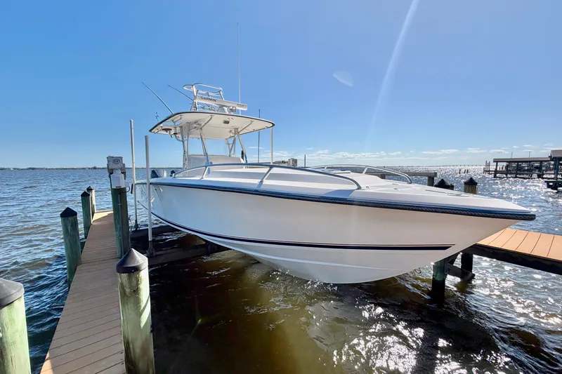 The Image of 2004 Venture 34 Cuddy boat docked on a sunny day by the water. - 0