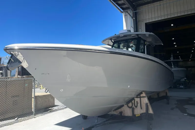 Slide: The Image of 2024 Boston Whaler 360 Outrage boat in a shipyard under clear blue sky. - 72
