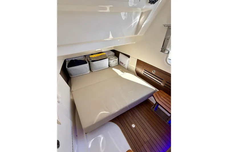 Slide: The Image of 2024 Boston Whaler 360 Outrage cabin interior with cushioned seating and wooden flooring. - 43