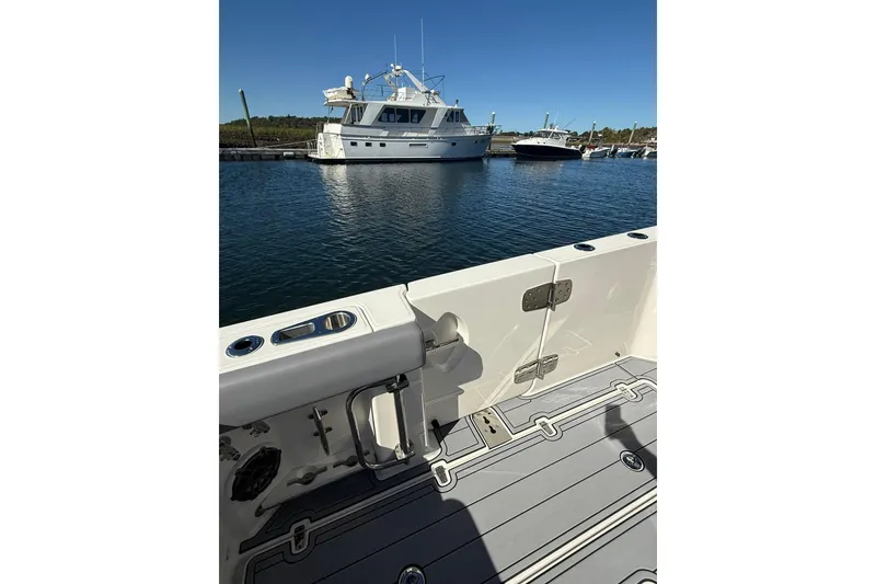 Slide: The Image of 2024 Boston Whaler 360 Outrage boat interior with marina view in background. - 32