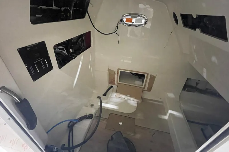 Slide: The Image of Interior view of 2024 Boston Whaler 360 Outrage boat cabin, featuring control panels and storage. - 60