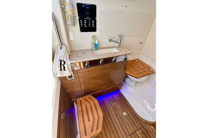 Slide: The Image of Luxurious interior of 2024 Boston Whaler 360 Outrage boat with wooden cabinetry and modern fixtures. - 40