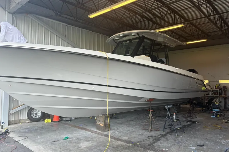 Slide: The Image of 2024 Boston Whaler 360 Outrage boat in a workshop setting. - 89
