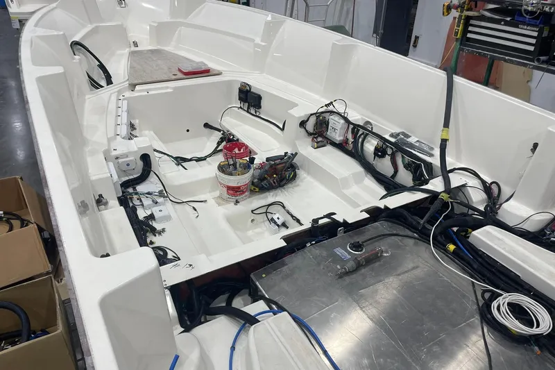 Slide: The Image of 2024 Boston Whaler 360 Outrage boat interior under construction, showcasing wiring and components. - 46