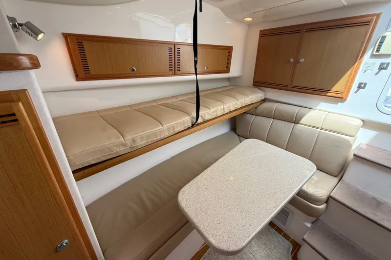 Slide: The Image of 2007 Cabo 32 Express cabin interior with beige seating and wooden cabinets. - 63