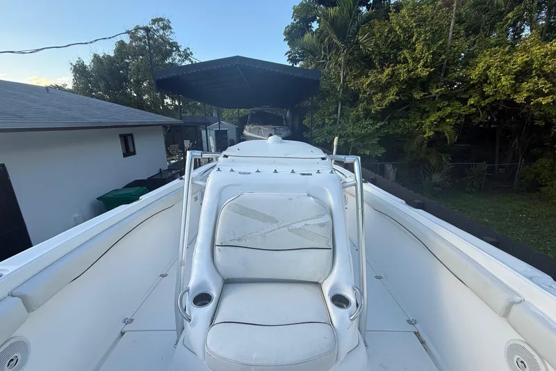 Slide: The Image of 2004 Wellcraft 32 CCF boat with white seating, parked outdoors near trees. - 54
