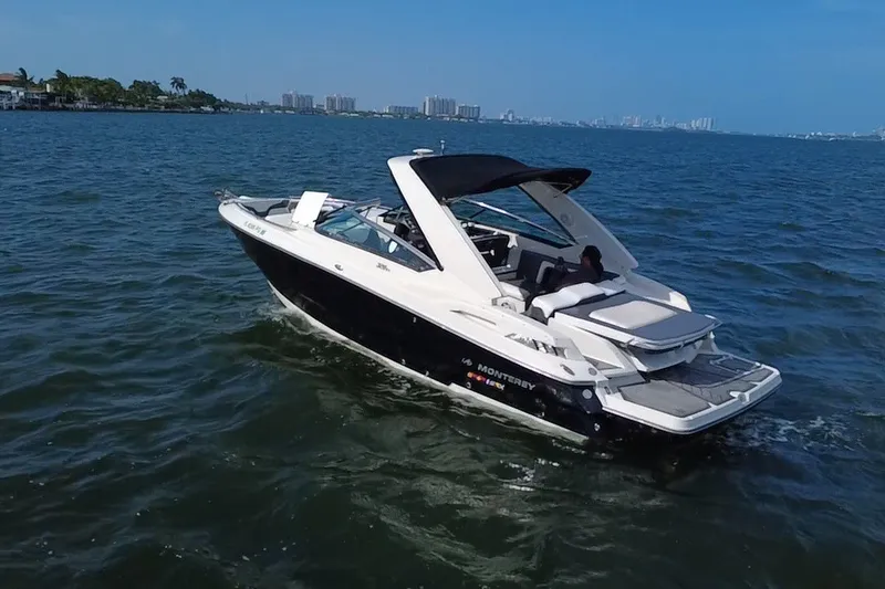 Slide: The Image of 2011 Monterey 328SS Super Sport boat cruising on open water under clear blue skies. - 2