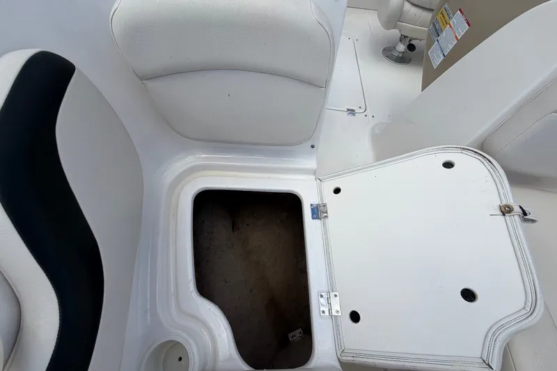 Slide: The Image of Un compartiment de rangement ouvert sur un bateau blanc avec des sièges rembourrés et un accent noir. - 45