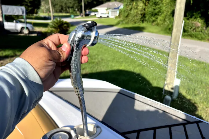 Slide: The Image of Hand holding a boat shower sprayer on a 2019 Glastron GTD 220. - 55