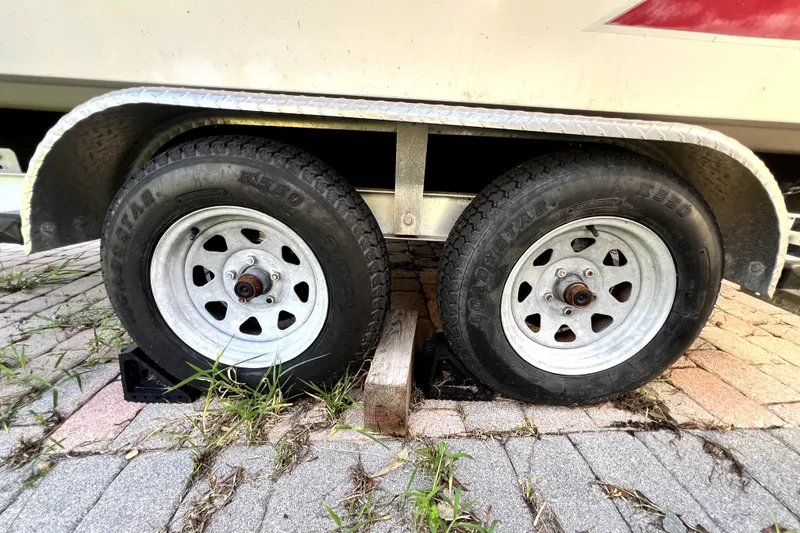 Slide: The Image of Trailer wheels of a 2019 Glastron GTD 220 boat on a paved surface. - 73