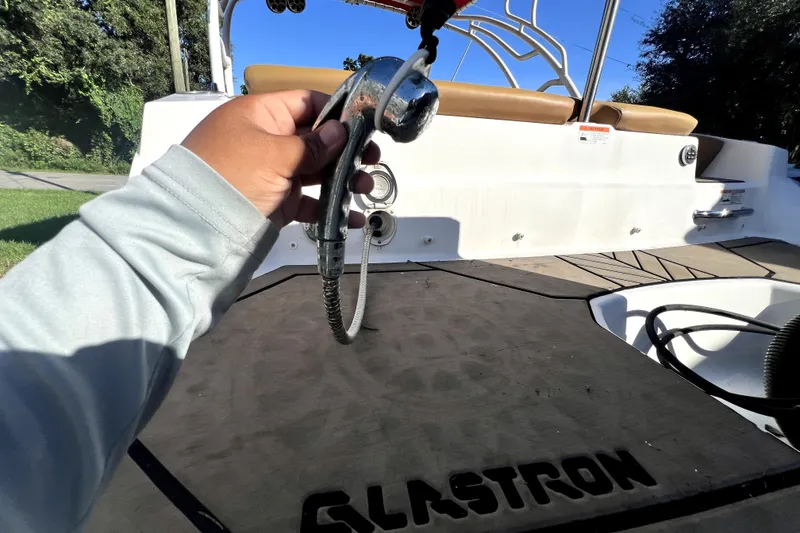 Slide: The Image of Person holding a showerhead on a 2019 Glastron GTD 220 boat deck. - 65