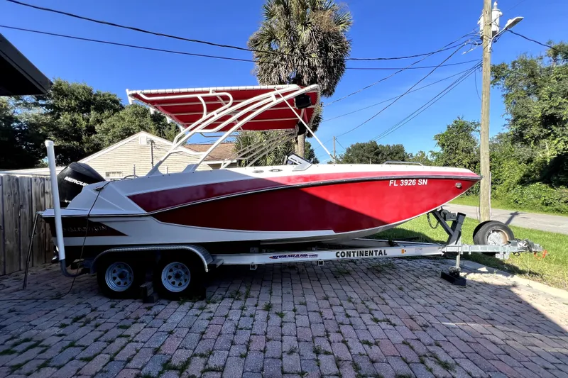 Slide: The Image of 2019 Glastron GTD 220 boat on trailer, red and white design, parked outdoors. - 24