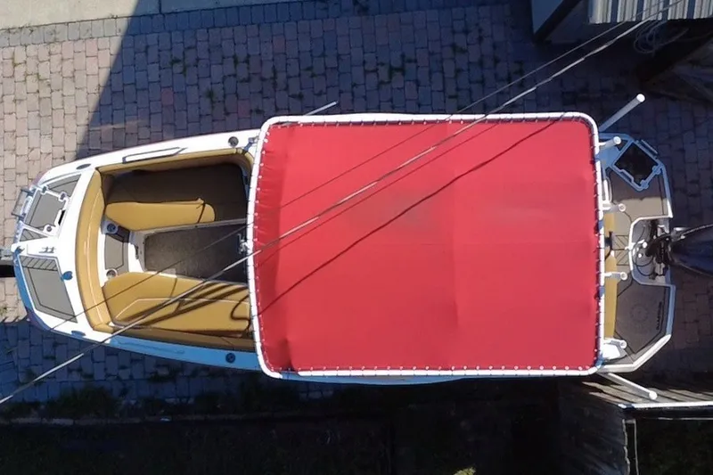 Slide: The Image of Overhead view of 2019 Glastron GTD 220 boat with red canopy on brick driveway. - 25