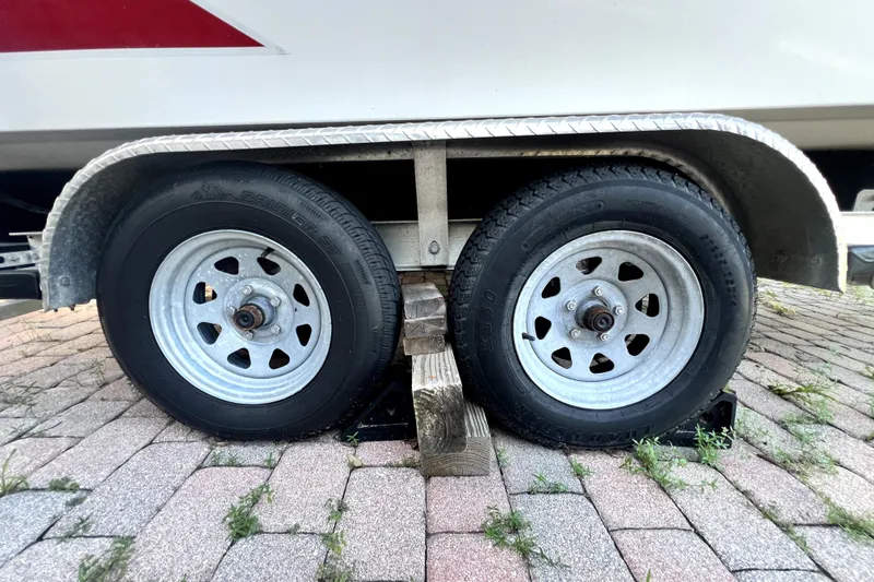 Slide: The Image of Trailer wheels of a 2019 Glastron GTD 220 boat on a brick driveway. - 72