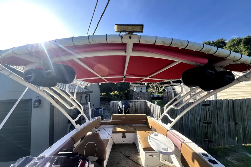 Slide: The Image of 2019 Glastron GTD 220 boat with red canopy and spacious seating area. - 35