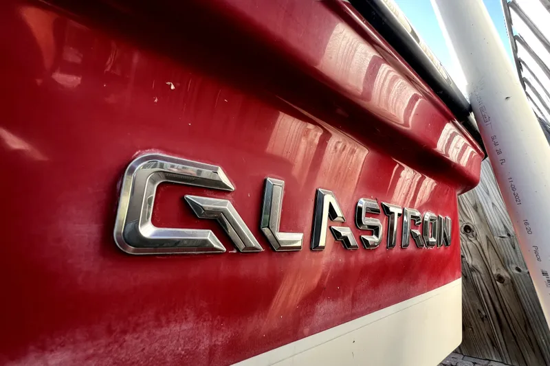 Slide: The Image of Red 2019 Glastron GTD 220 boat with chrome logo detail. - 13