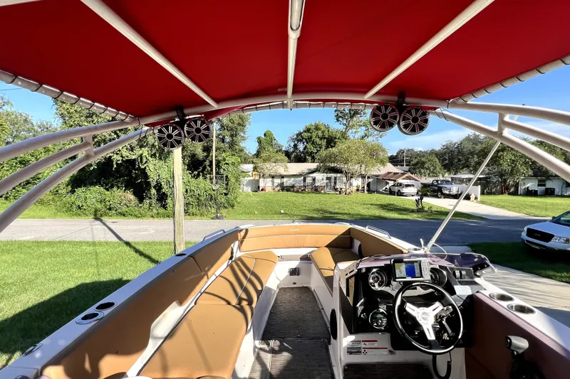 Slide: The Image of 2019 Glastron GTD 220 boat interior with red canopy and tan seating. - 26