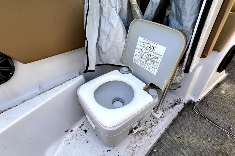 Slide: The Image of Portable toilet on a 2019 Glastron GTD 220 boat, with instruction labels visible. - 56