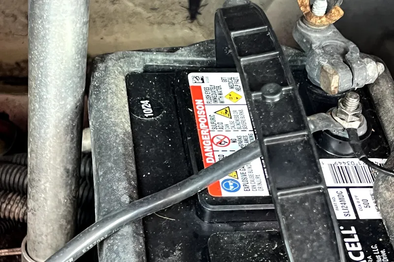 Slide: The Image of Battery compartment of a 2019 Glastron GTD 220 boat, showing warning labels and cables. - 69